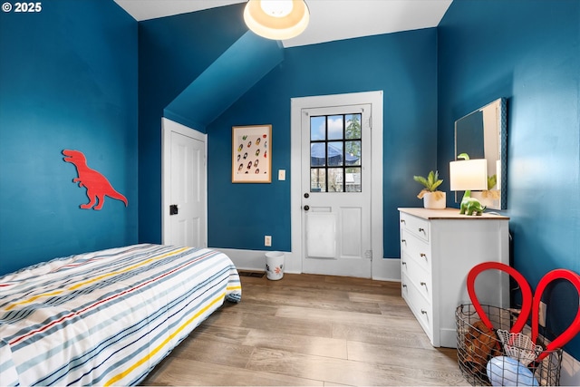 bedroom featuring lofted ceiling and wood finished floors