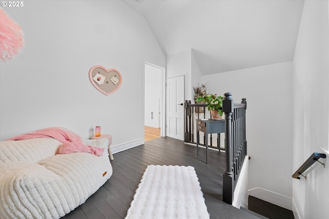 interior space with baseboards, vaulted ceiling, an upstairs landing, and hardwood / wood-style flooring