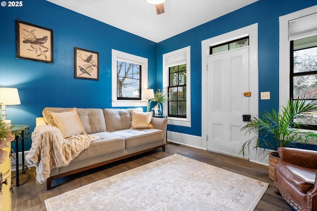 living room with visible vents, plenty of natural light, baseboards, and wood finished floors