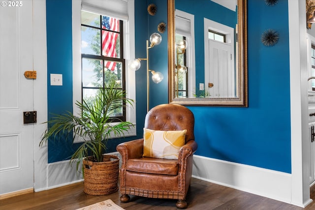 sitting room with baseboards and wood finished floors