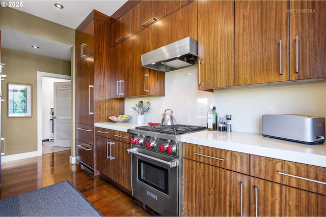 kitchen featuring extractor fan, dark wood-type flooring, and designer stove