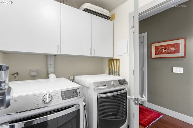 laundry area with independent washer and dryer, cabinets, and hardwood / wood-style flooring