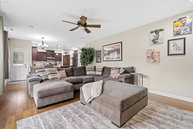 living room with recessed lighting, baseboards, wood-type flooring, and ceiling fan with notable chandelier