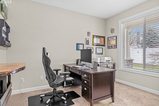 office area featuring light carpet and baseboards