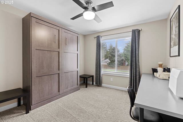 office space featuring light carpet, baseboards, and a ceiling fan