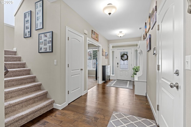 foyer entrance featuring stairs, baseboards, and dark wood-style flooring