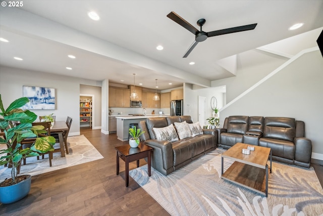 living room with ceiling fan and dark hardwood / wood-style floors