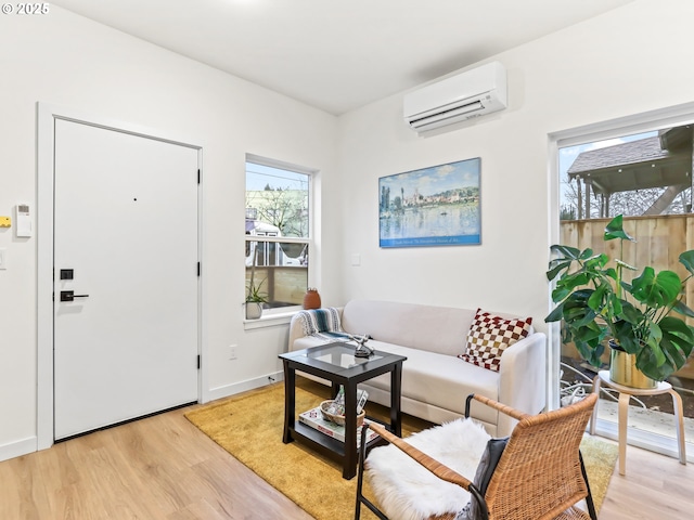 living room with light wood-type flooring and a wall unit AC