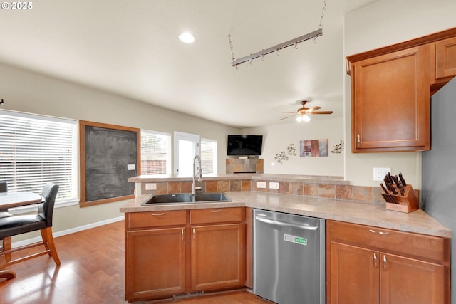 kitchen with sink, track lighting, appliances with stainless steel finishes, kitchen peninsula, and ceiling fan