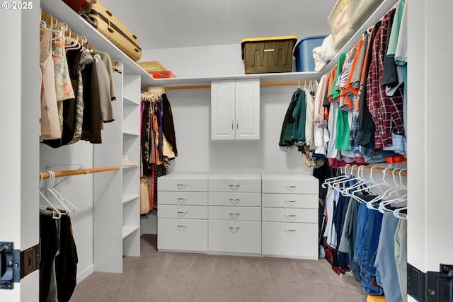 walk in closet featuring light colored carpet