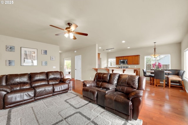 living room featuring ceiling fan and light hardwood / wood-style flooring