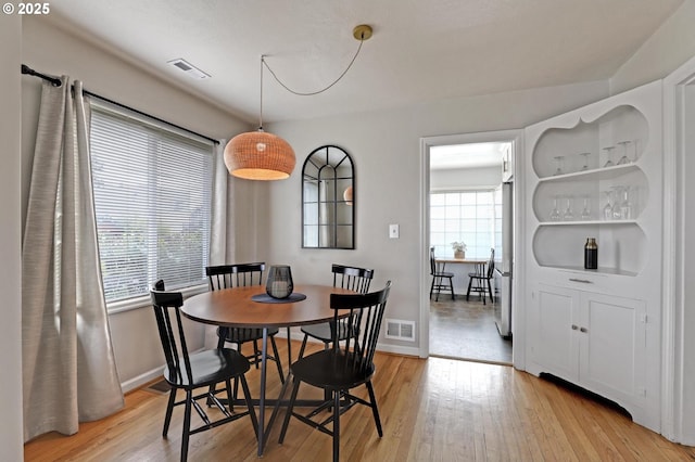 dining room featuring visible vents, baseboards, and light wood-style floors