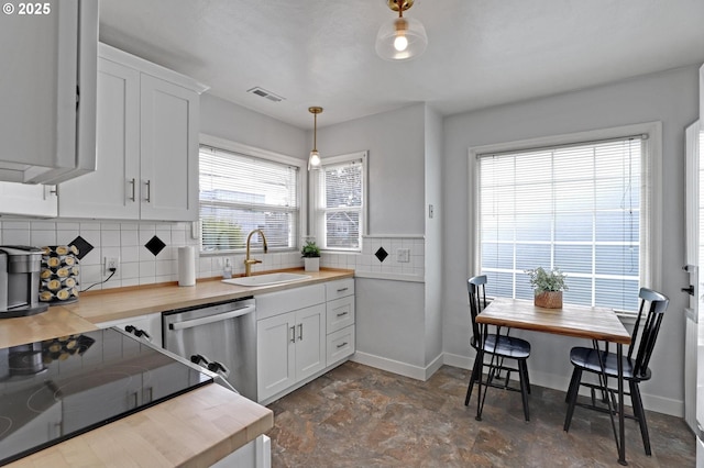 kitchen with tasteful backsplash, visible vents, a sink, decorative light fixtures, and stainless steel dishwasher