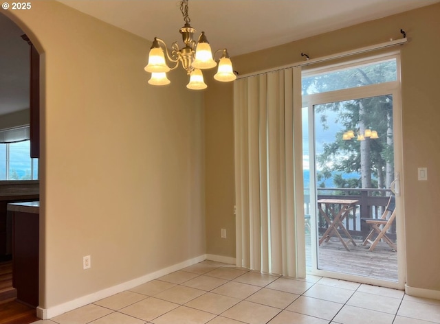 unfurnished dining area featuring light tile patterned floors and a chandelier