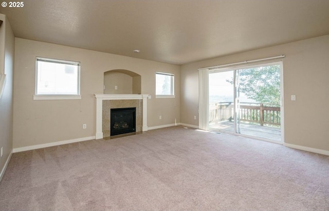 unfurnished living room featuring light colored carpet and a tile fireplace