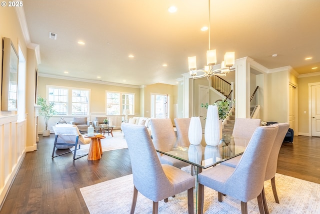 dining space featuring a notable chandelier, crown molding, stairs, dark wood-type flooring, and visible vents