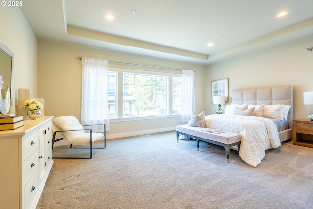 bedroom featuring a tray ceiling, baseboards, recessed lighting, and light colored carpet