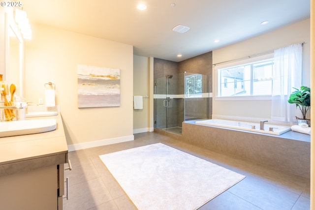 full bathroom featuring a sink, double vanity, a shower stall, tile patterned floors, and a garden tub