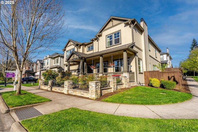 craftsman-style house featuring a chimney, board and batten siding, a front yard, a porch, and fence