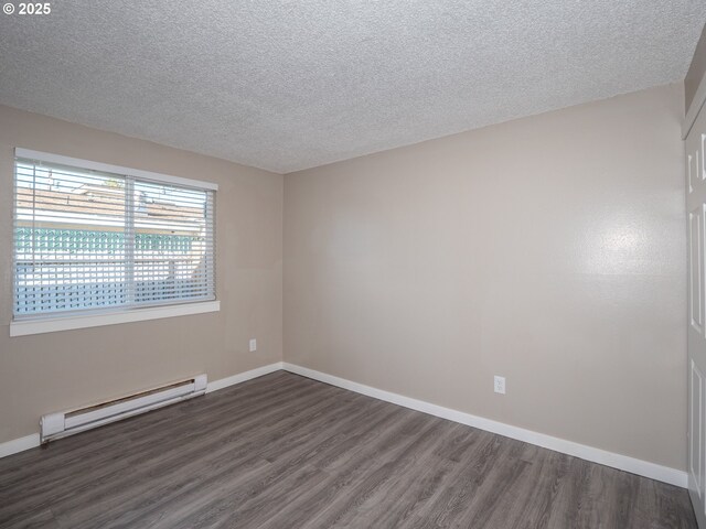 7450 N Portsmouth Ave, Portland, OR 97203 - empty room featuring dark wood finished floors, a baseboard radiator, baseboards, and a textured ceiling