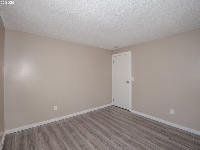 7450 N Portsmouth Ave, Portland, OR 97203 - unfurnished room featuring baseboards, wood finished floors, and a textured ceiling