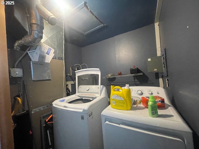 clothes washing area featuring heating unit, laundry area, and washing machine and dryer