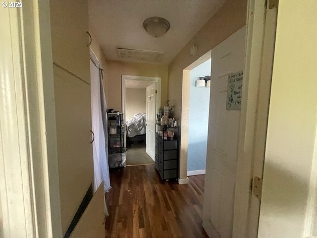 corridor with baseboards and dark wood-type flooring