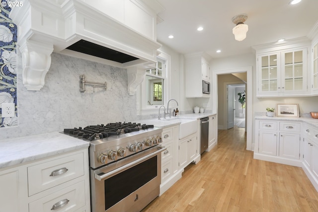 1805 SW Elizabeth St, Portland, OR 97201 - kitchen with appliances with stainless steel finishes, a sink, white cabinetry, tasteful backsplash, and recessed lighting