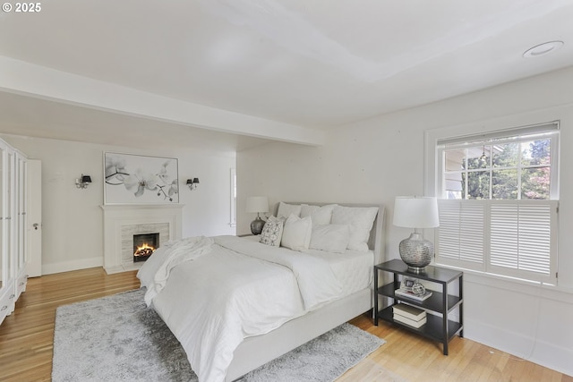 1805 SW Elizabeth St, Portland, OR 97201 - bedroom featuring wood finished floors, a warm lit fireplace, and baseboards