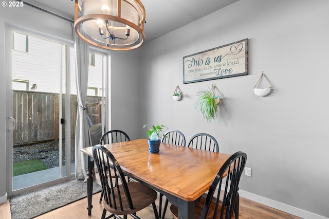 dining space featuring baseboards and a notable chandelier