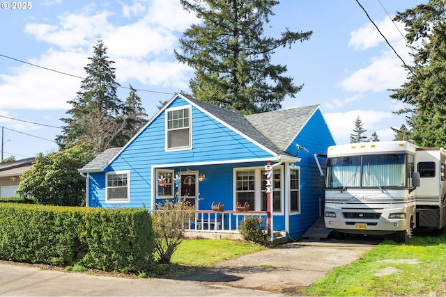 bungalow with a porch and roof with shingles