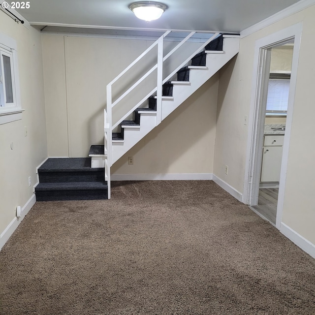 below grade area featuring carpet floors, stairs, and baseboards