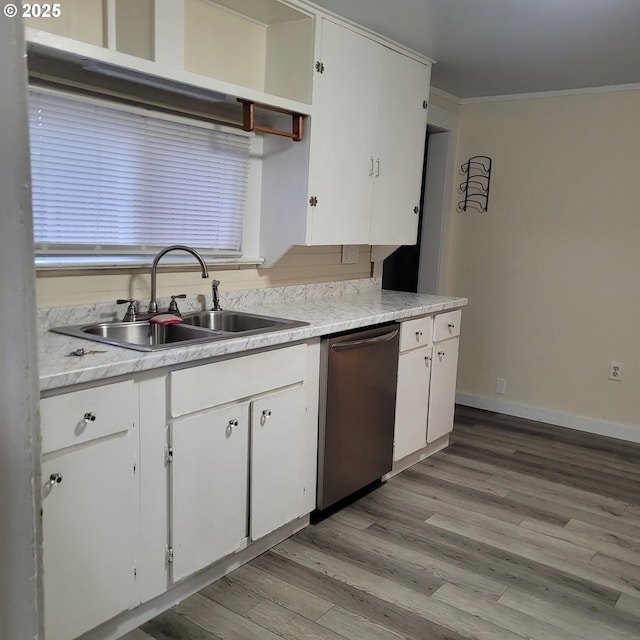 kitchen with a sink, white cabinets, ornamental molding, stainless steel dishwasher, and light wood-type flooring