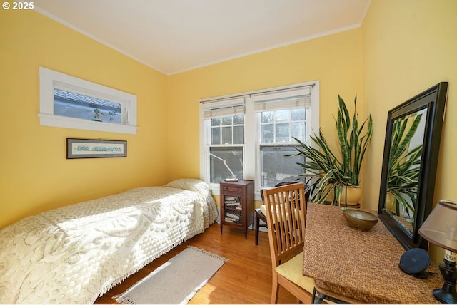 bedroom with crown molding and wood finished floors