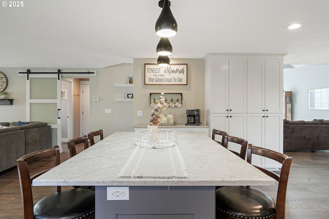 dining room with dark wood-style floors, a barn door, and recessed lighting