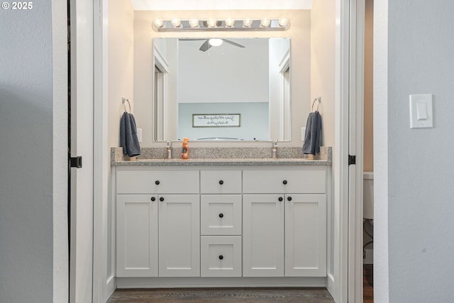 bathroom featuring ceiling fan, double vanity, and a sink