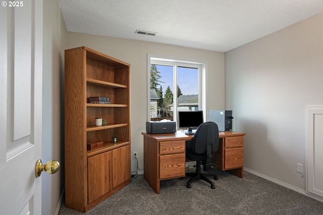 office space with a textured ceiling, dark colored carpet, visible vents, and baseboards