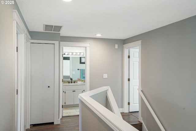 hall featuring recessed lighting, a sink, an upstairs landing, visible vents, and dark wood-style floors