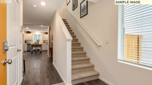 stairs with baseboards, wood finished floors, and recessed lighting