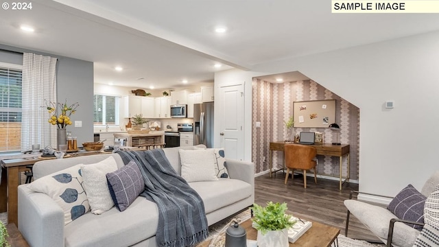 living area featuring recessed lighting, wallpapered walls, wood finished floors, and baseboards