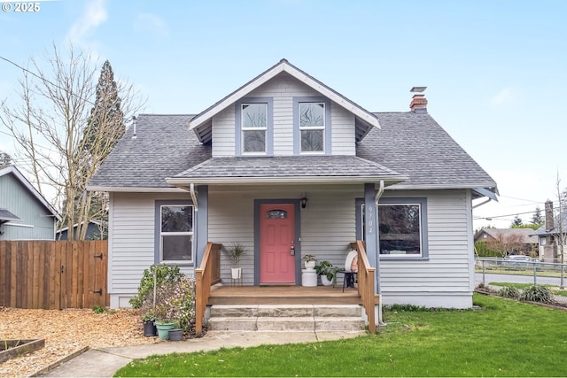 bungalow-style home with a porch, fence, a front lawn, and a shingled roof