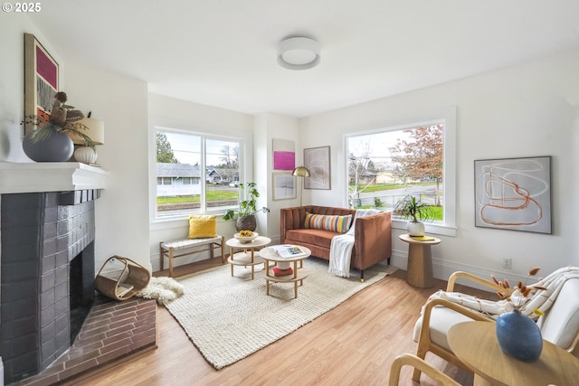 living room with baseboards, wood finished floors, and a fireplace