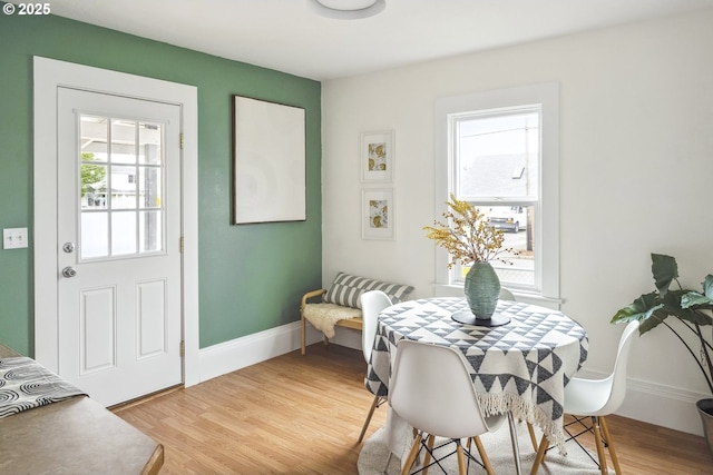 dining space featuring baseboards and light wood-style flooring