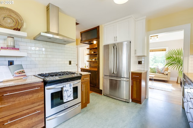 7154 N Greeley Ave, Portland, OR 97217 - kitchen featuring appliances with stainless steel finishes, wall chimney range hood, open shelves, backsplash, and white cabinets
