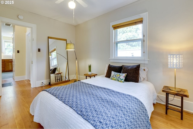 7154 N Greeley Ave, Portland, OR 97217 - bedroom with multiple windows, wood finished floors, baseboards, ornamental molding, and a ceiling fan
