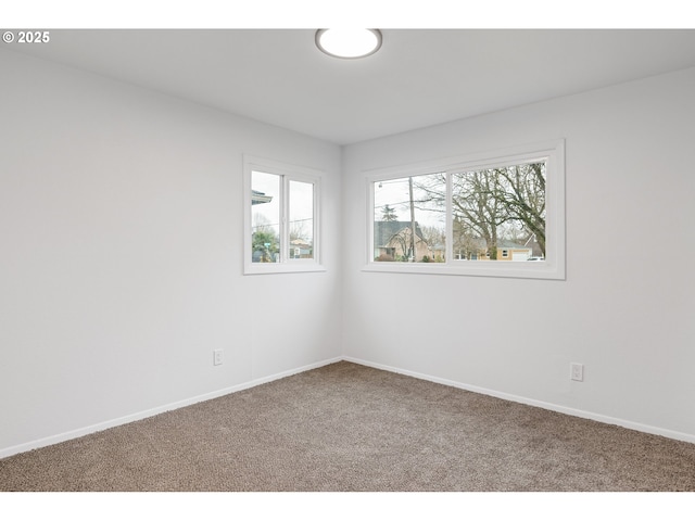 carpeted empty room with baseboards