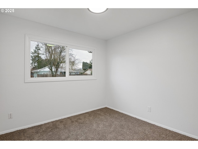 carpeted empty room featuring baseboards