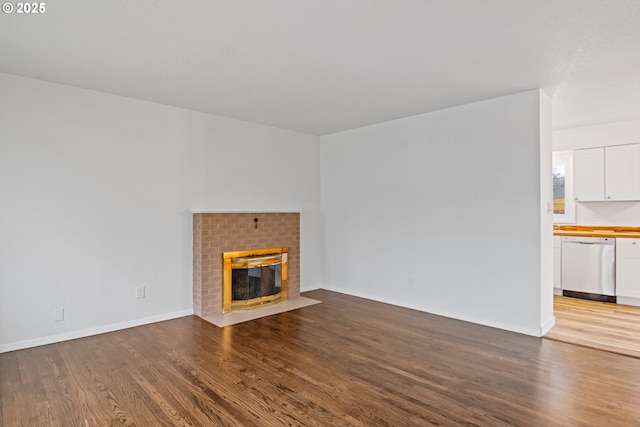 unfurnished living room featuring light wood-type flooring, a fireplace, and baseboards