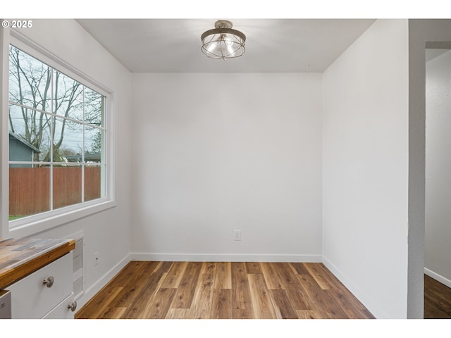 unfurnished room featuring wood finished floors and baseboards