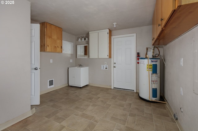 clothes washing area with visible vents, laundry area, electric water heater, and baseboards